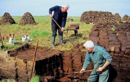 Falkland Islanders cutting peat to store and dry at shacks next to homes. Peat for centuries has been the natural fuel to cook and heat homes in the Islands 